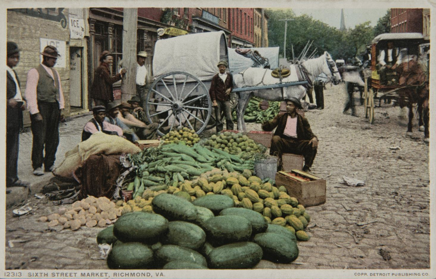 A group of men around a large pile of vegetables in the street. A horse and wagon are behind them.